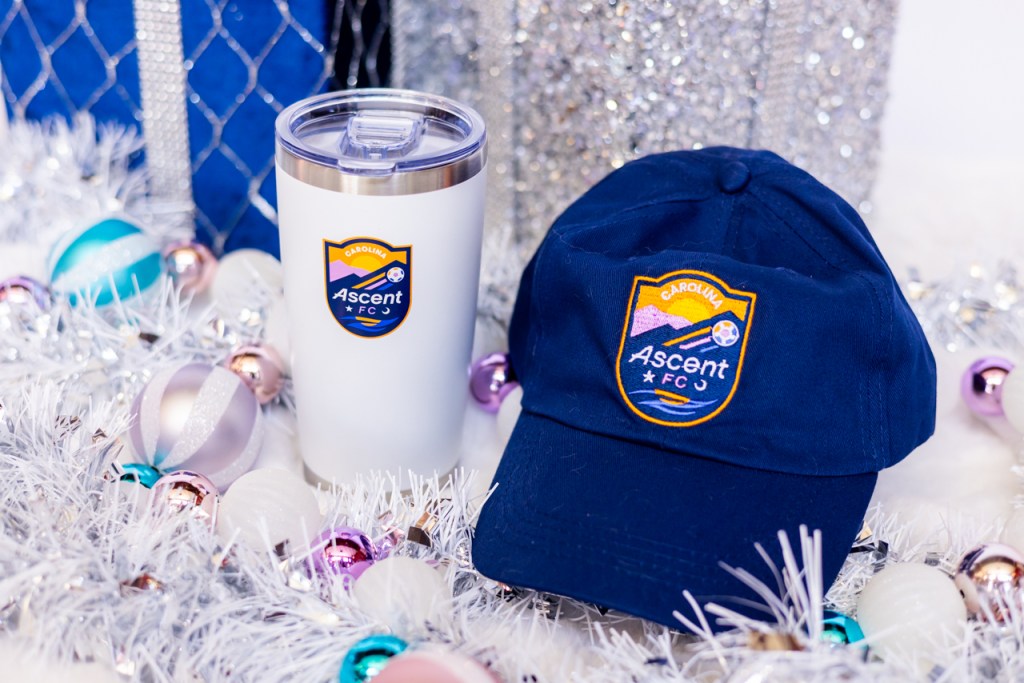 Carolina Ascent FC Hat and Tumbler surrounded by holiday decorations.